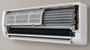 Illustrative cutaway of a wall-mounted mini-split showing its mesh filter, finned indoor coil, and condensate tray.
